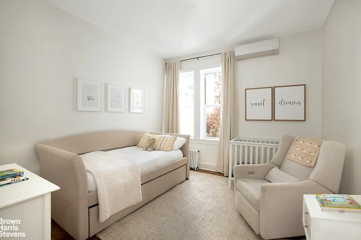 bedroom staged as a nursery with white walls, mini split