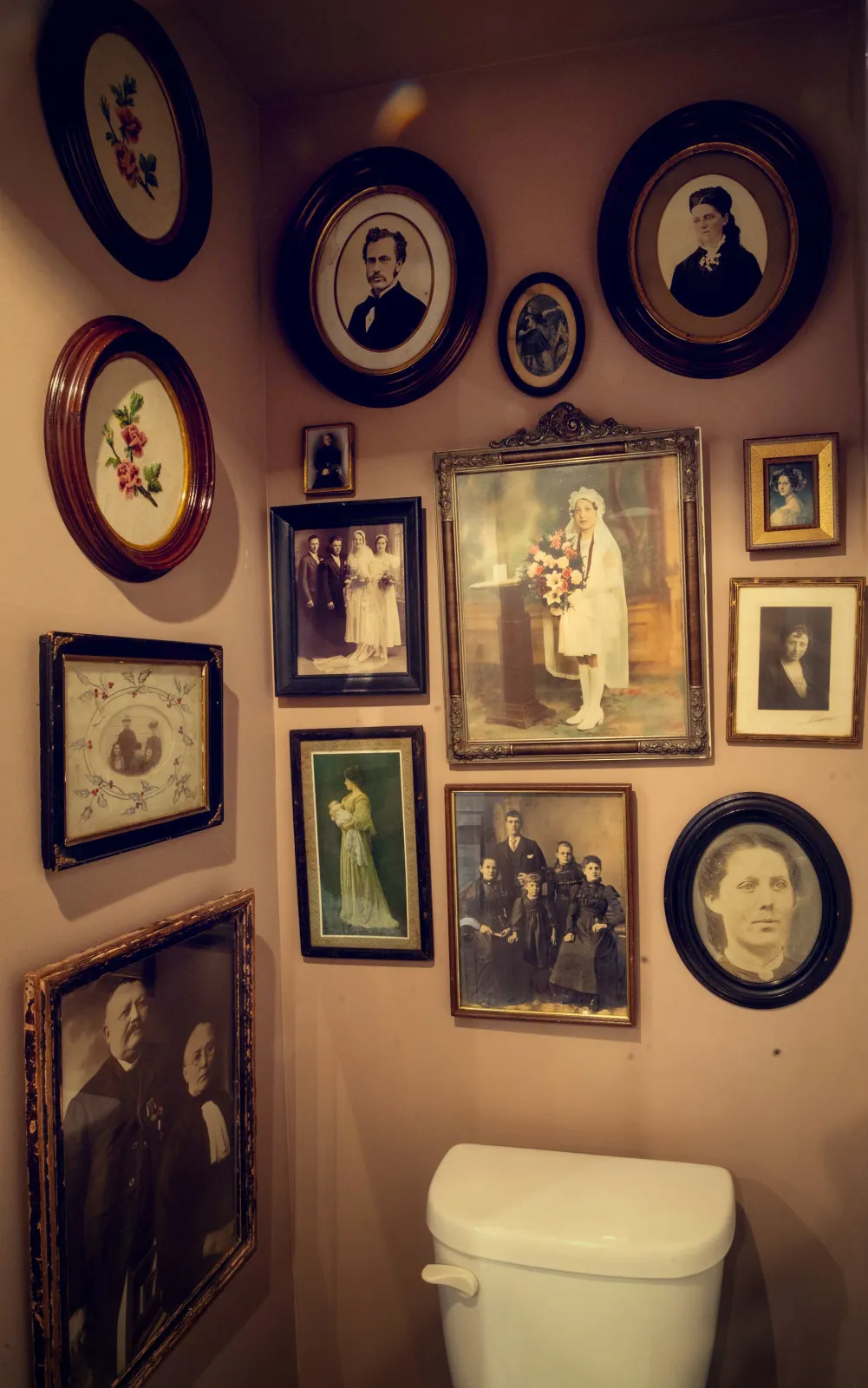 powder room with vintage portraits on the walls
