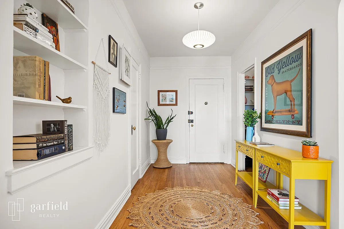 foywer with wood floor, white walls, niche with shelves