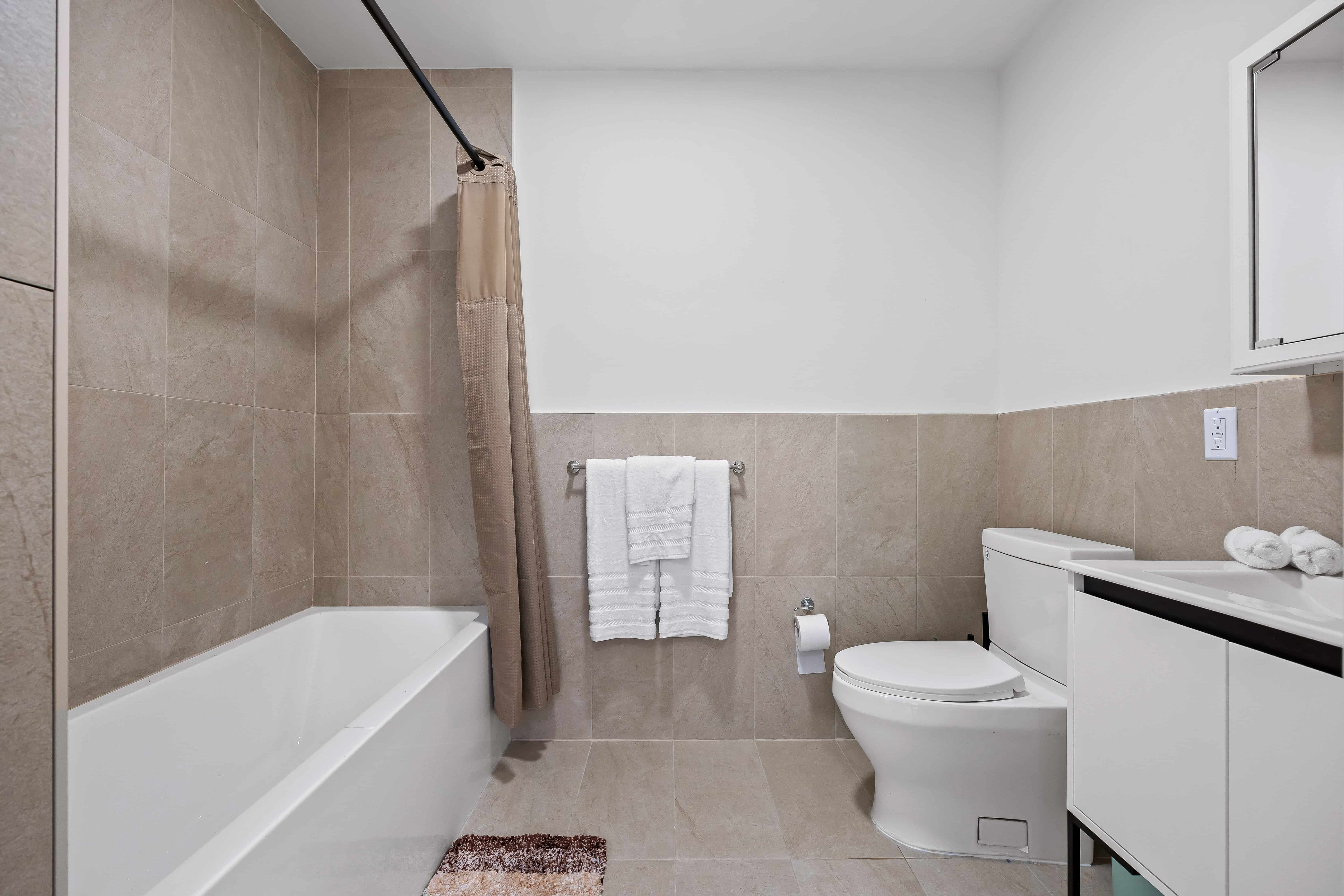 bathroom with beige tile and white fixtures