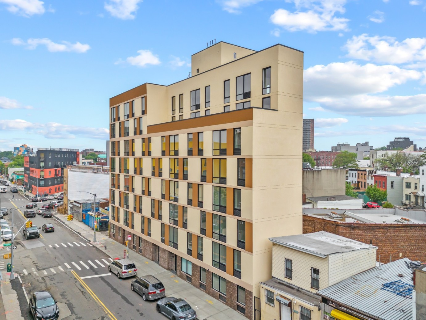 new building with brick base and brown upper stories