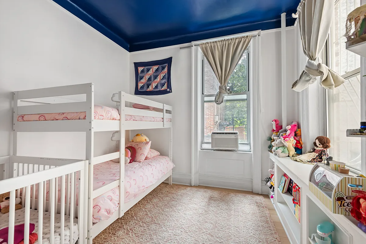 bedroom with blue ceiling and set up with bunkbeds and a crib