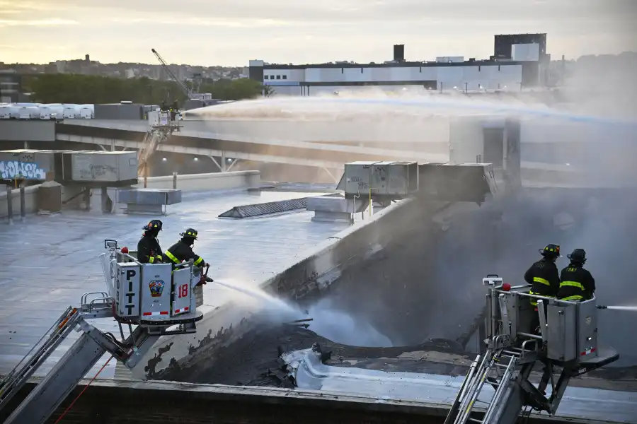 firefighters aiming water at a roof