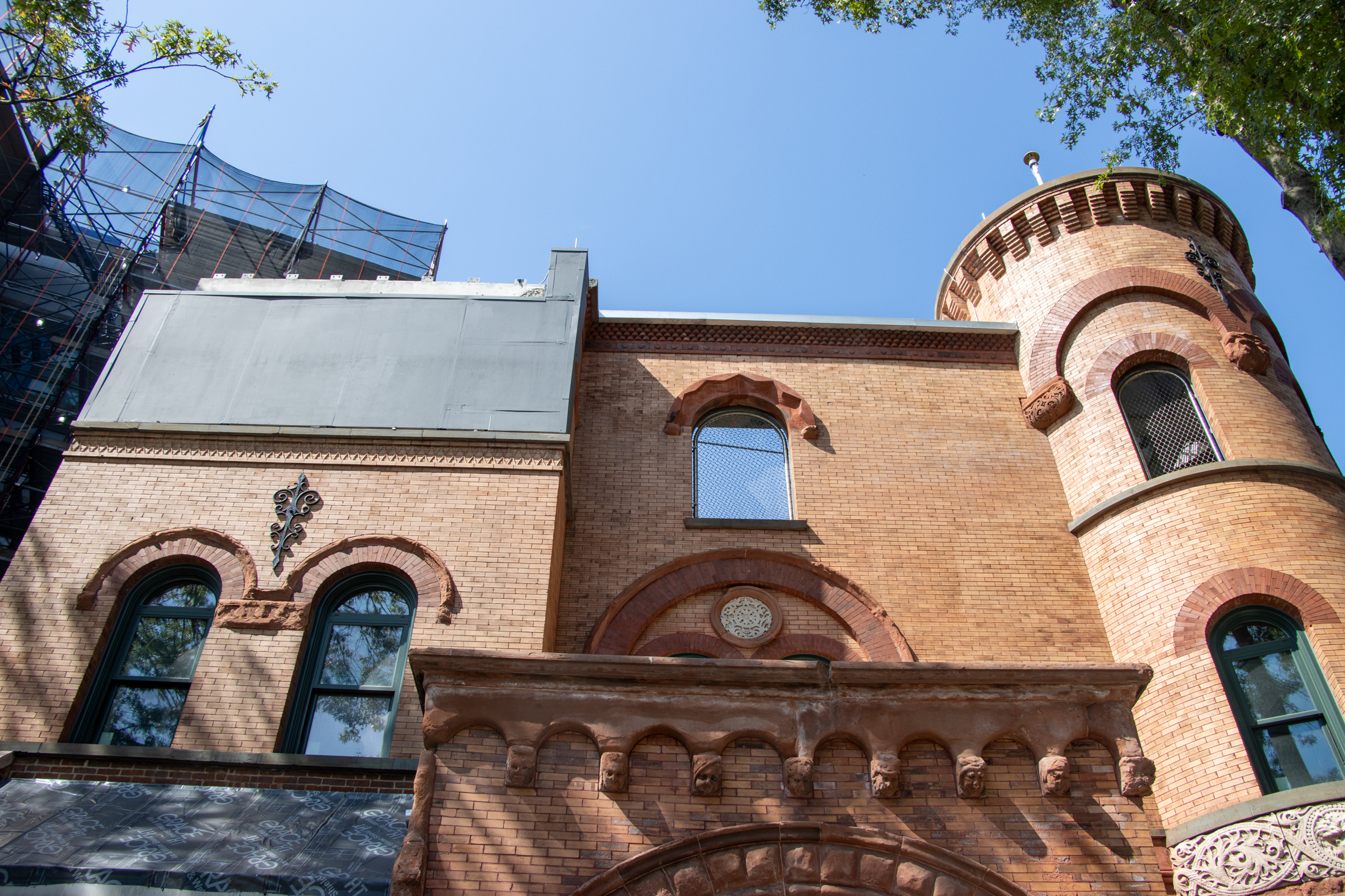 historic brick facade with chain link fencing in upper windows