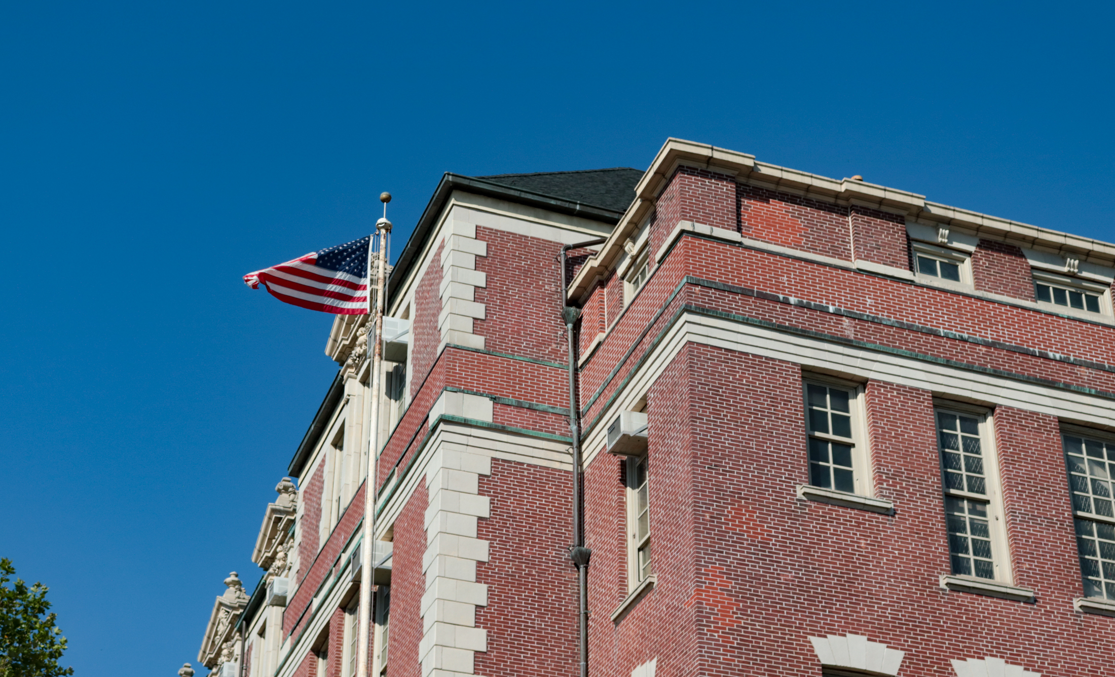 flag waving in front of a brick sunset park school