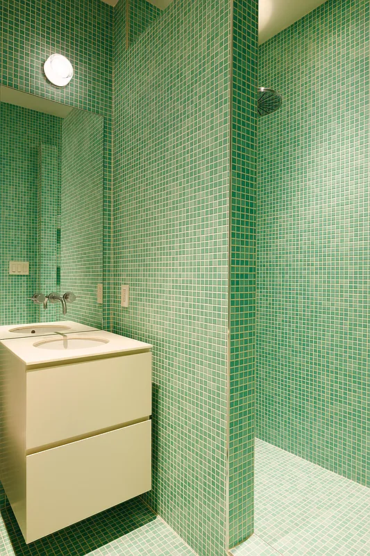 bathroom with walk-in shower with green mosaic tiles on the walls and floors