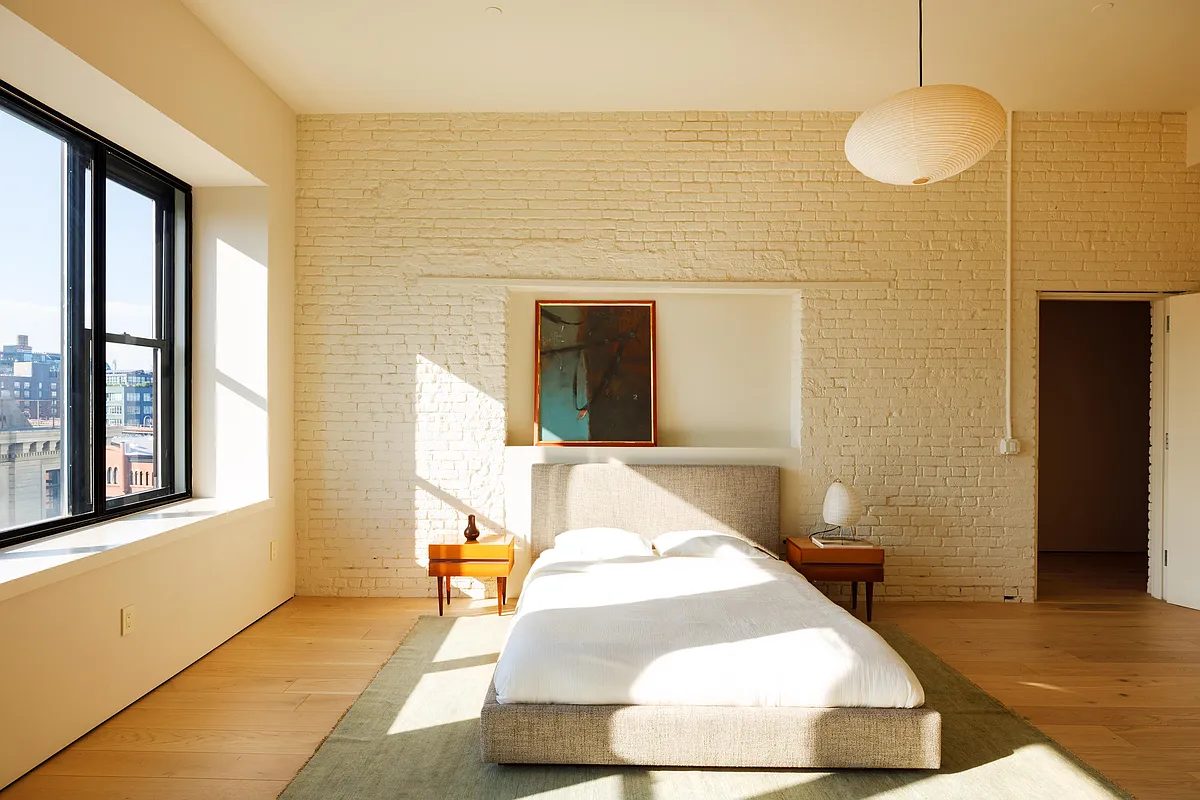 bedroom with one wall of exposed brick