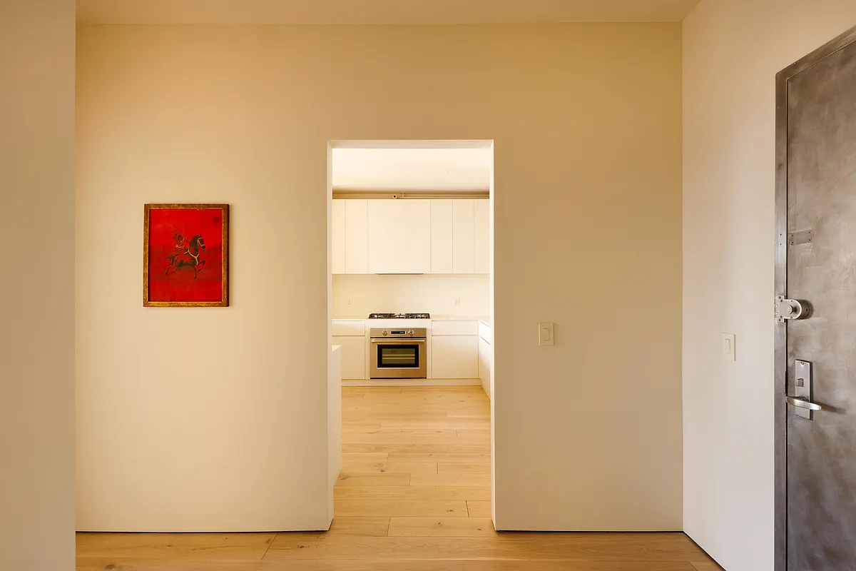 entry hall with cream walls and view into kitchen