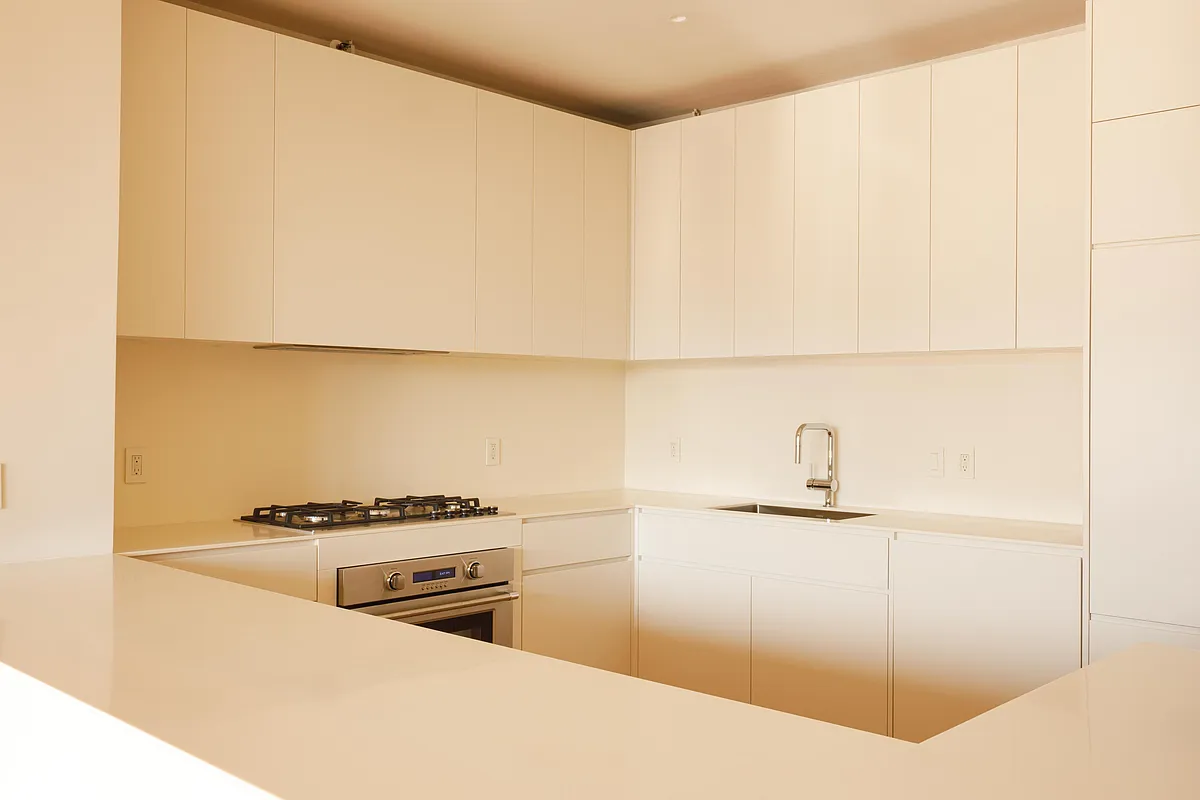 kitchen with cream cabinets including some that hide the fridge