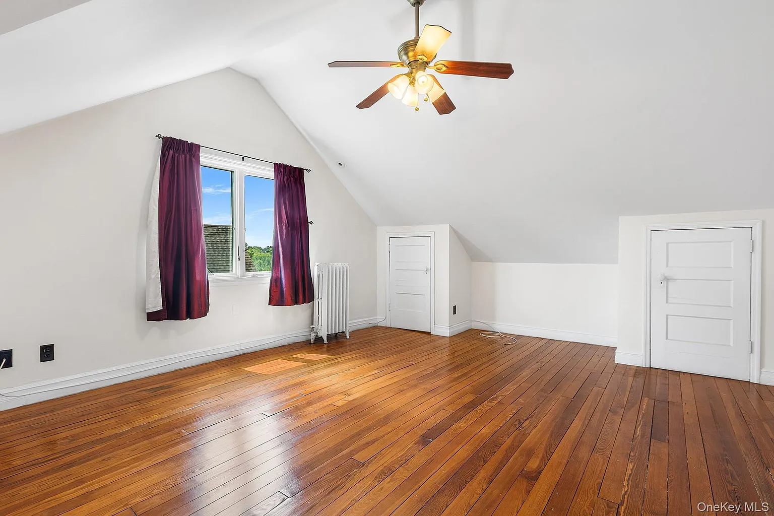 top floor bedroom with a ceiling fan
