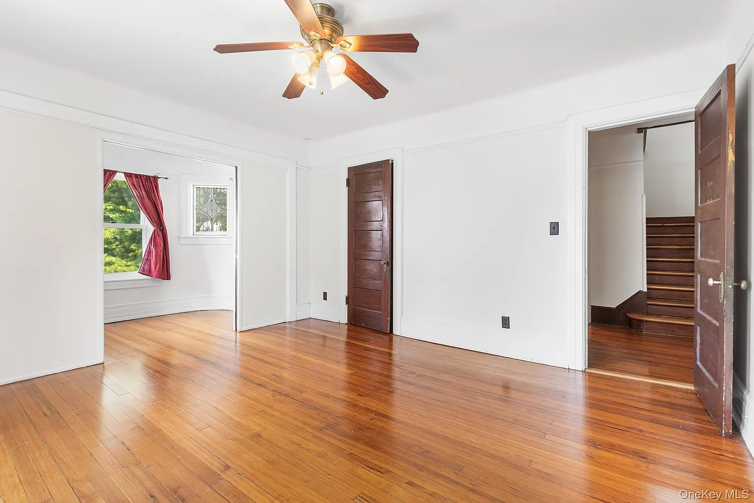 bedroom with ceiling fan, closet, view into another room