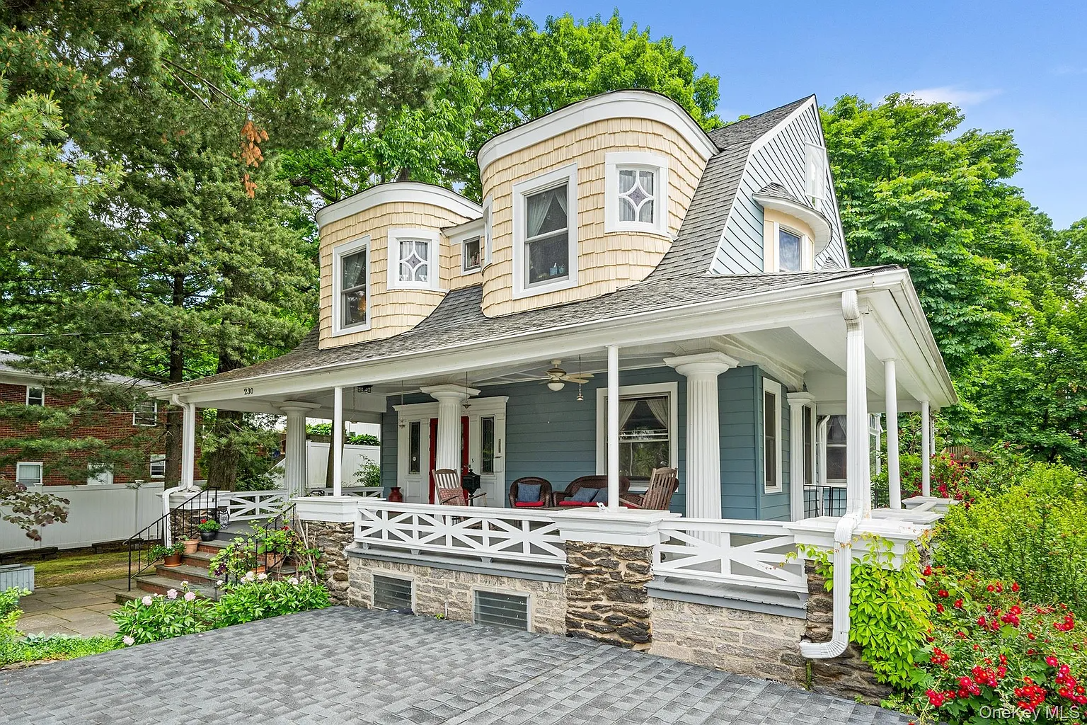 dutch colonial revival style house with gambrel roof and quirky, curved bays