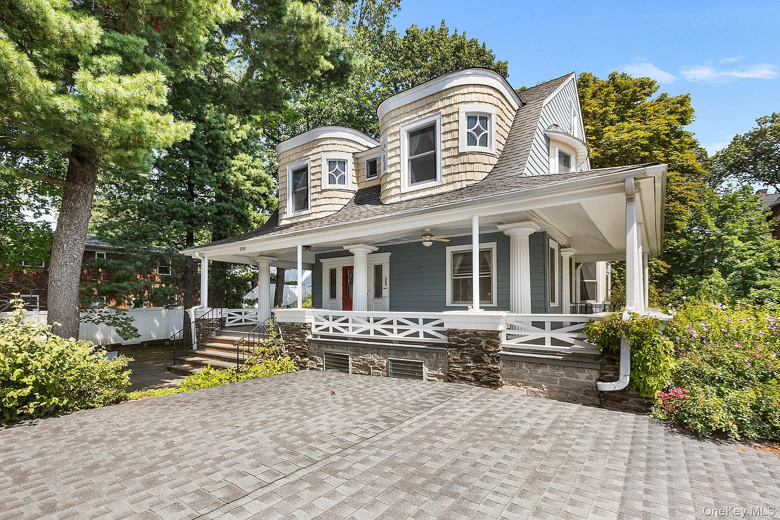 dutch colonial revival style house with gambrel roof and quirky, curved bays