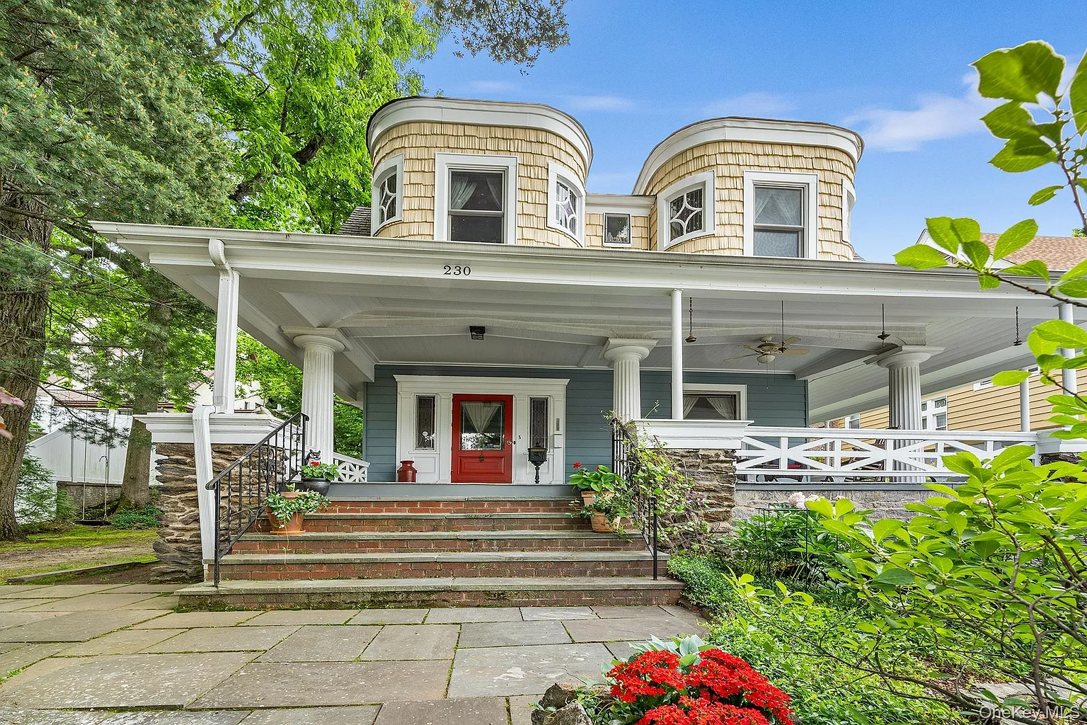 dutch colonial revival style house with gambrel roof and quirky, curved bays