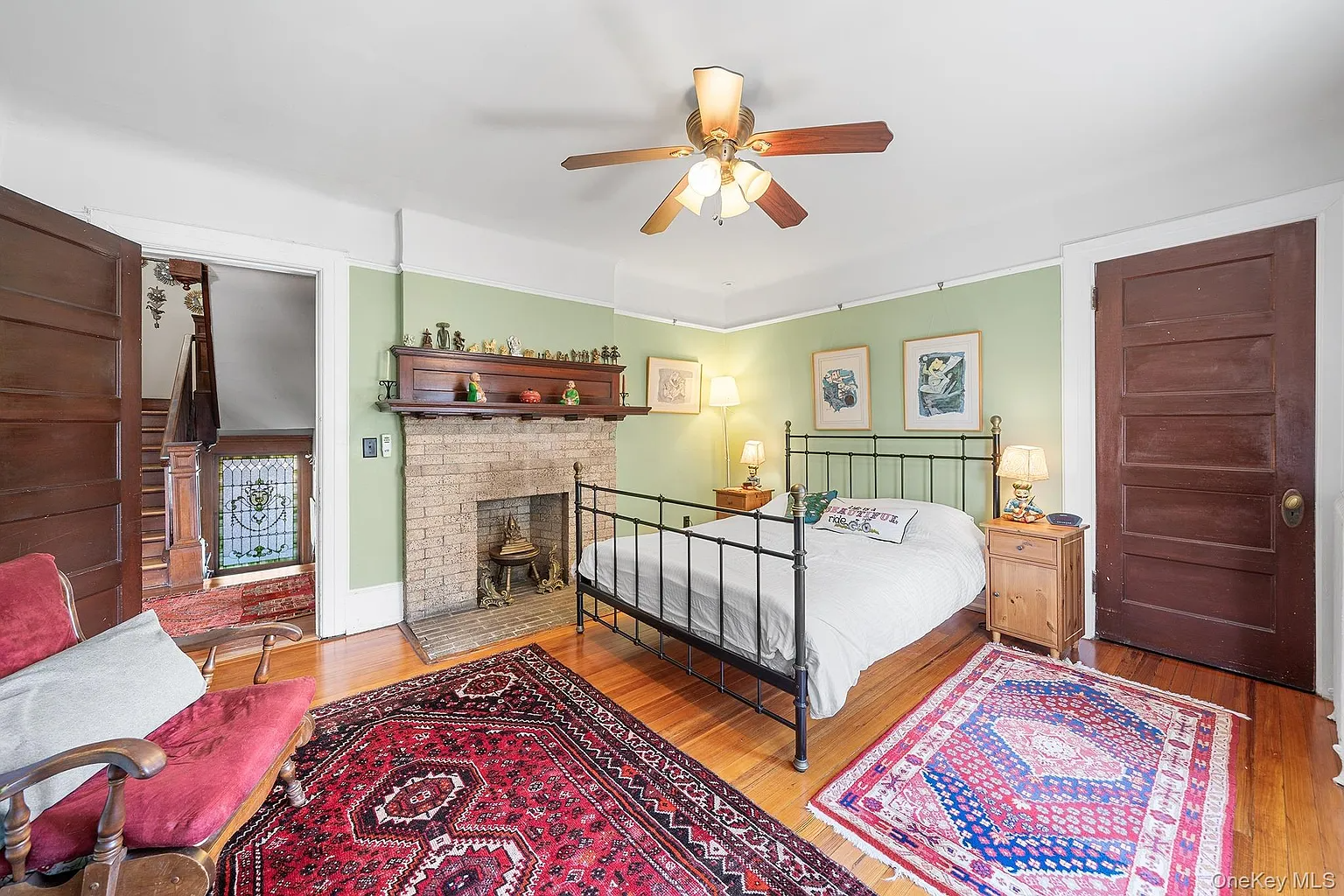 bedroom with a brick mantel furnished with a bed and sidetables