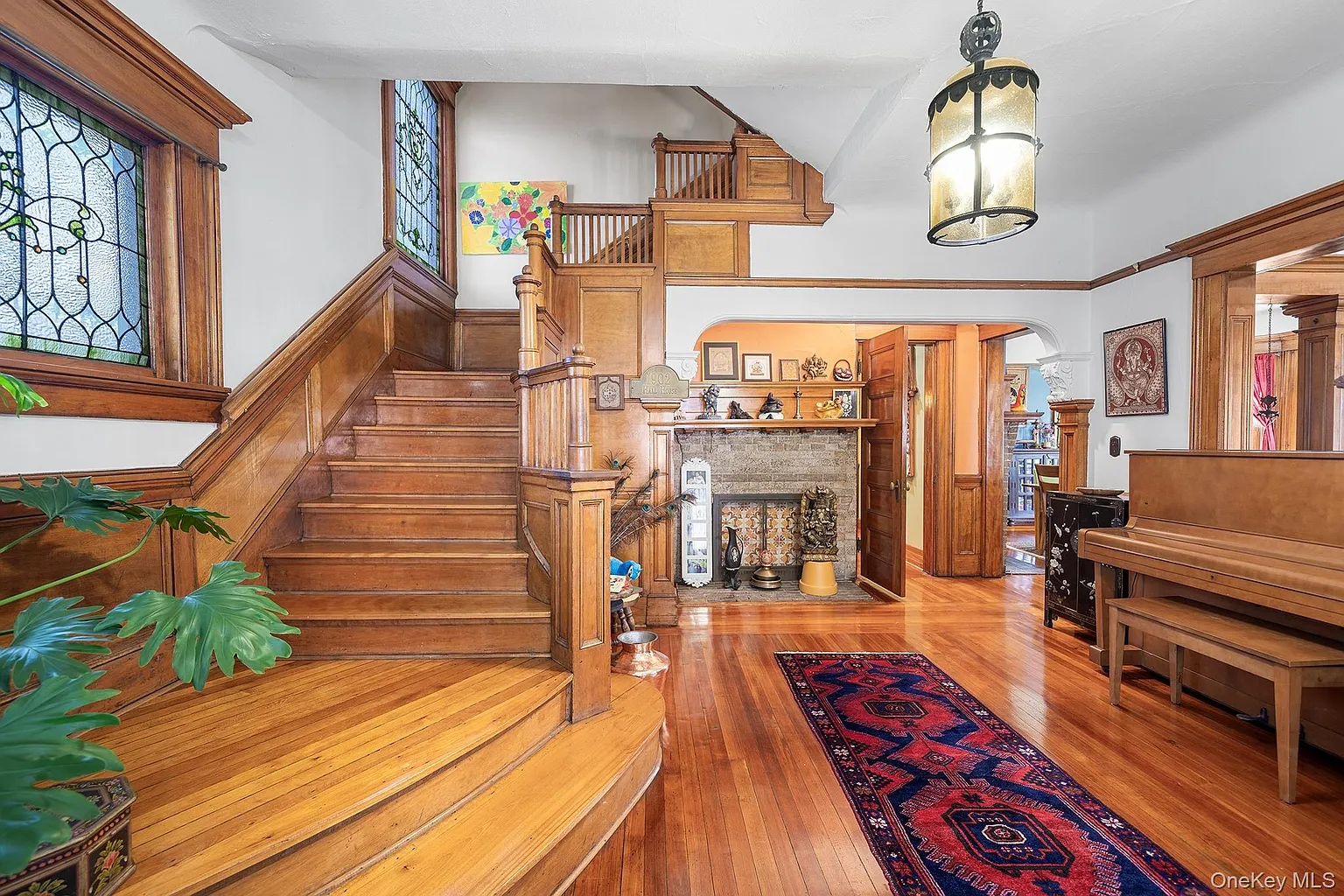 entry hall with wood stair, stained glass, fireplace
