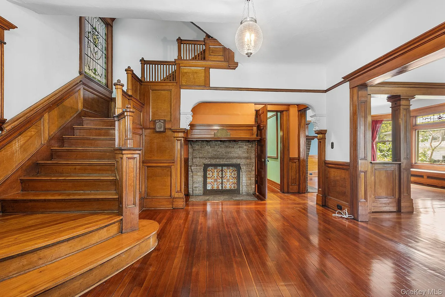 entry hall with wood stair, stained glass, fireplace