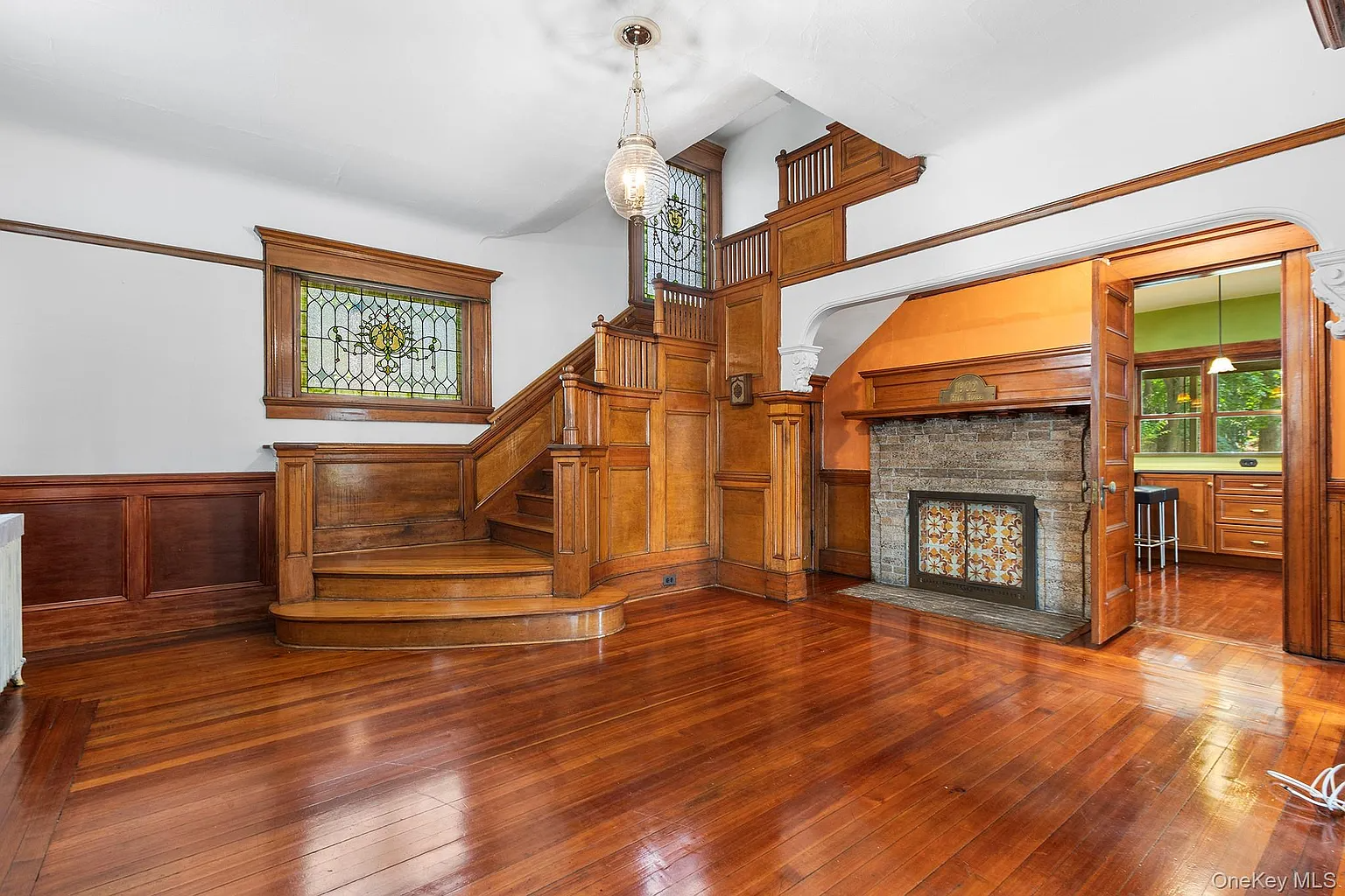 entry hall with wood stair, stained glass, fireplace