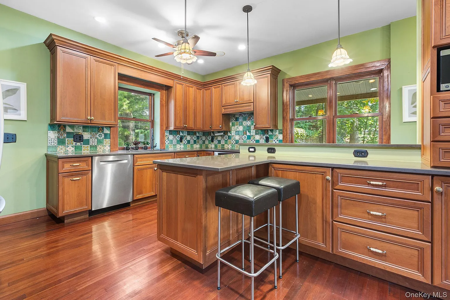 kitchen with green walls, green tile backsplash, wood cabinets