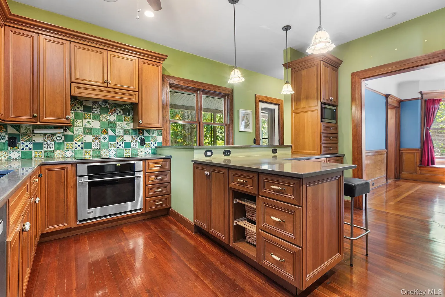 kitchen with green walls, green tile backsplash, wood cabinets