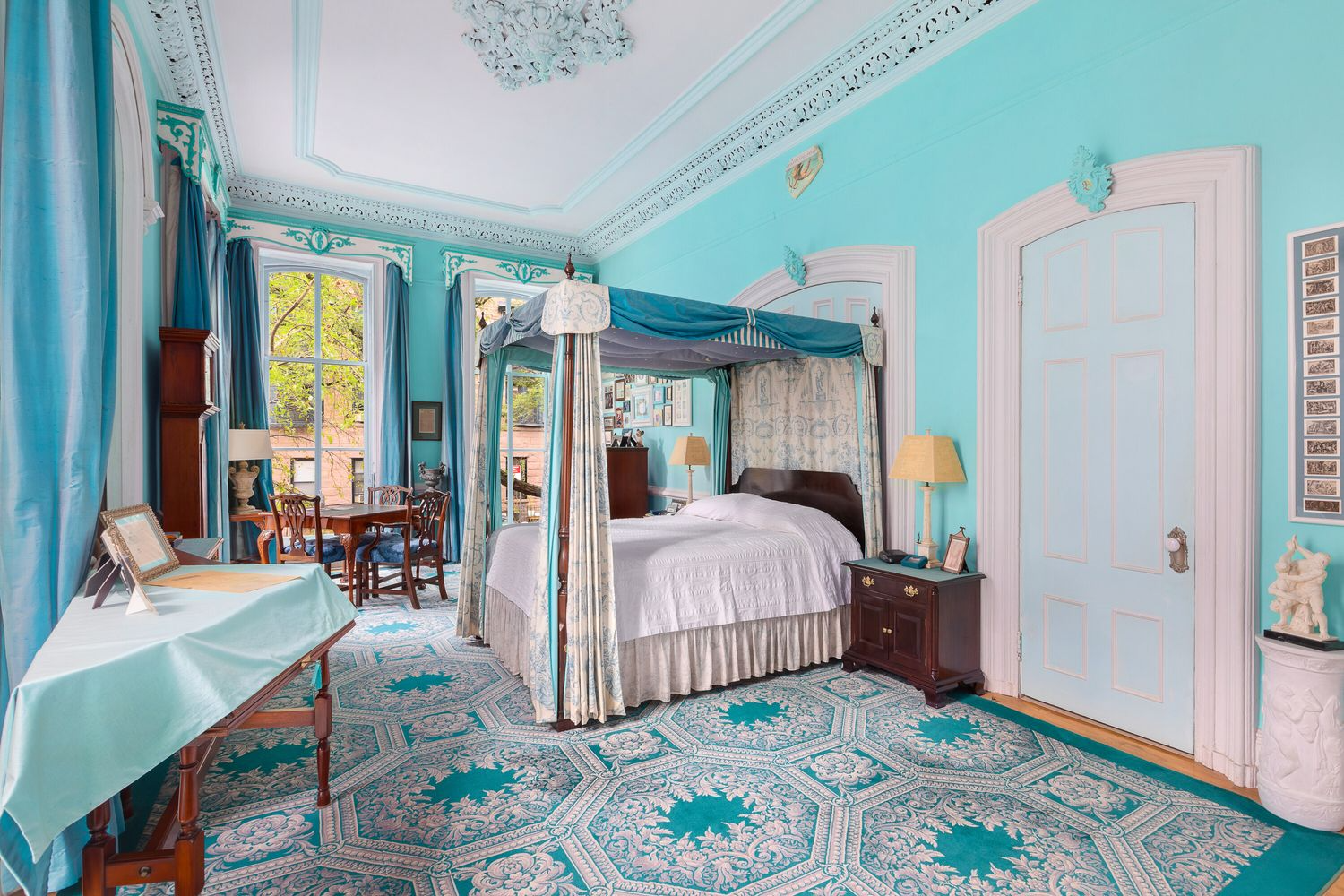bedroom with patterned blue and white carpet, blue walls, plasterwork painted light blue