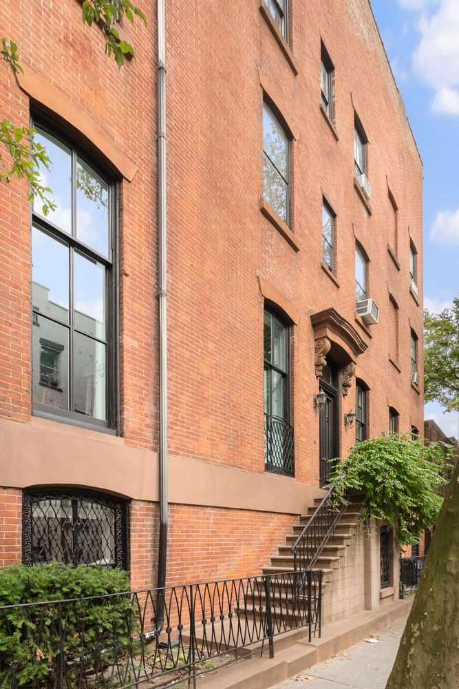 brick exterior with a stoop to a side entrance