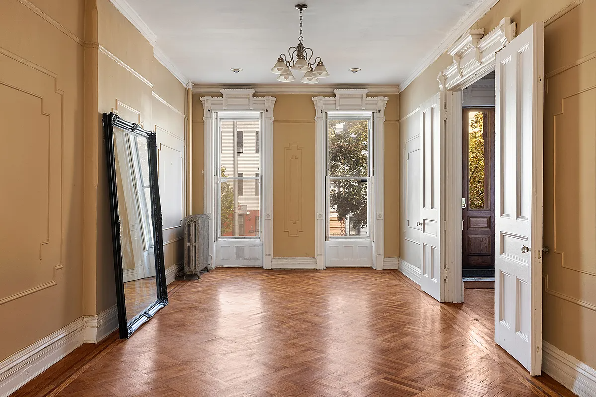 parlor with wall moldings, wood floor