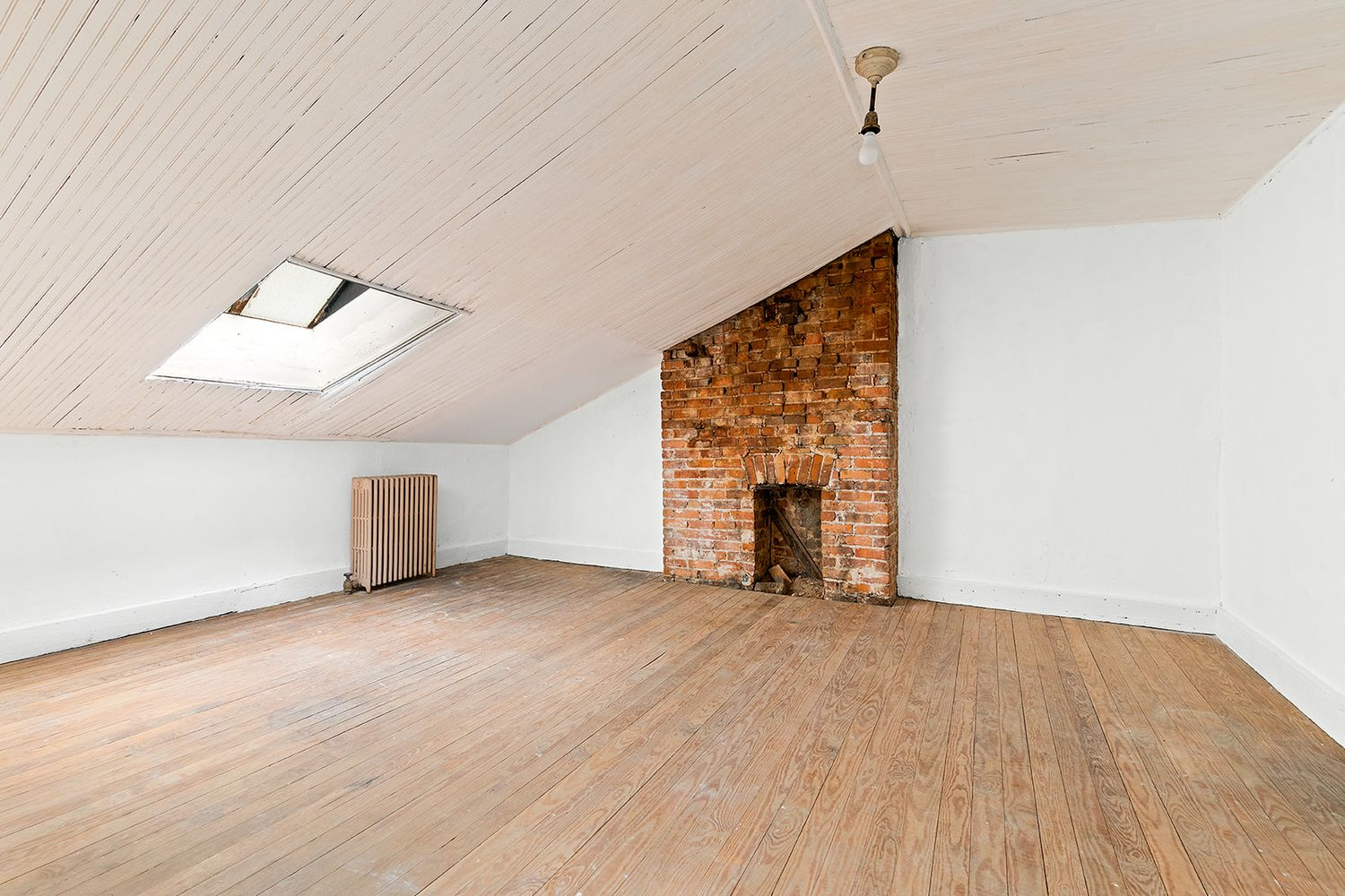 bedroom with sloped ceiling and a brick fireplace wall