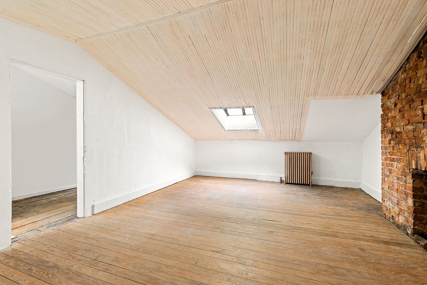 bedroom with wood slat ceiling and a brick fireplace wall