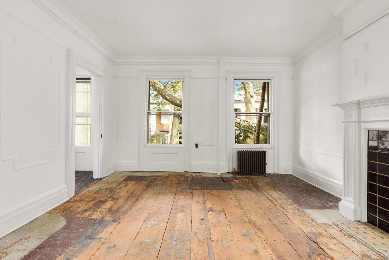 bedroom with wood floor, two windows, mantel