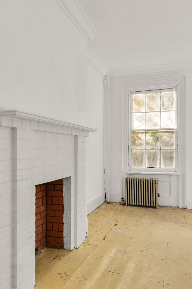 bedroom with linoleum floor and brick mantel