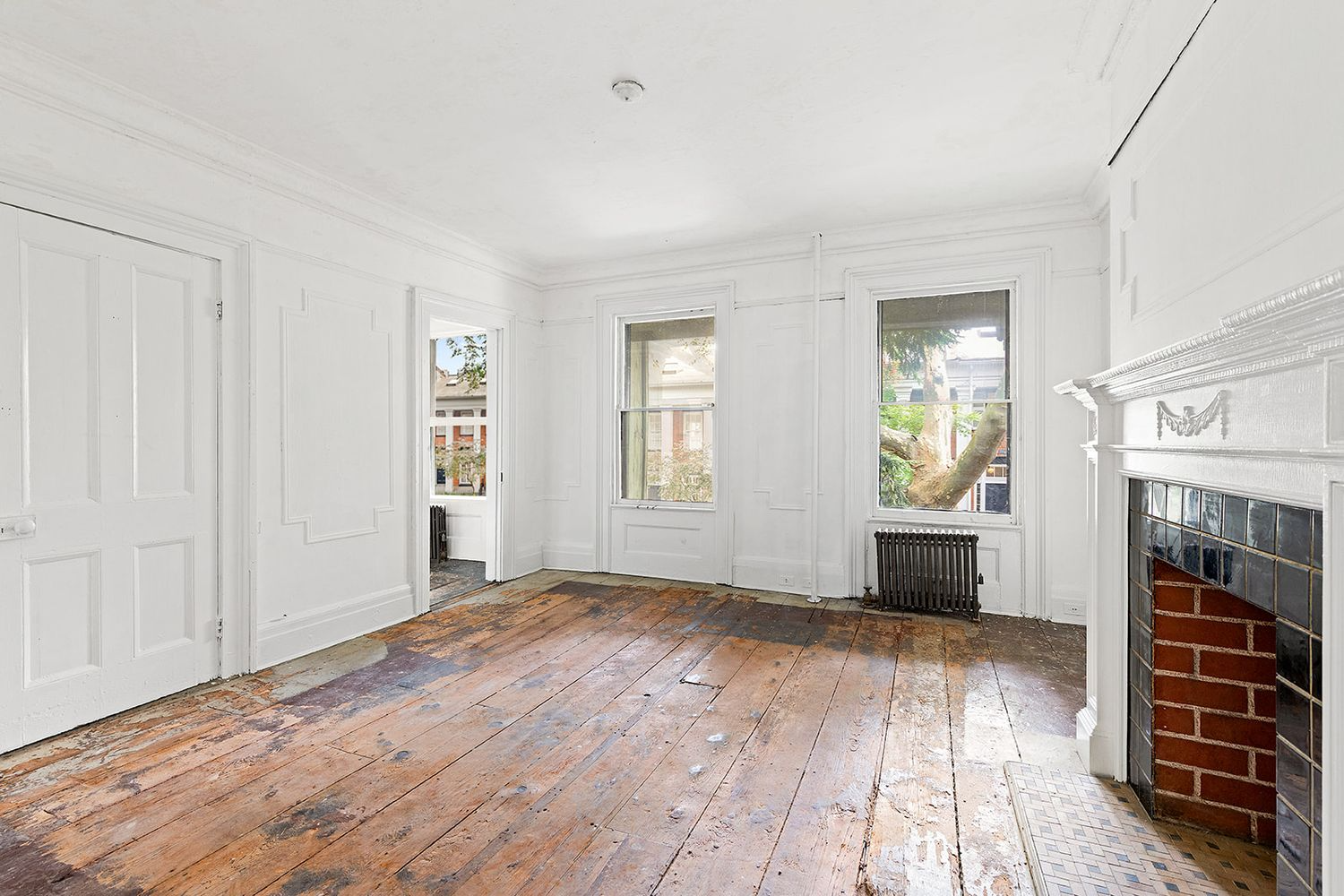 bedroom with wood floor, two windows, mantel