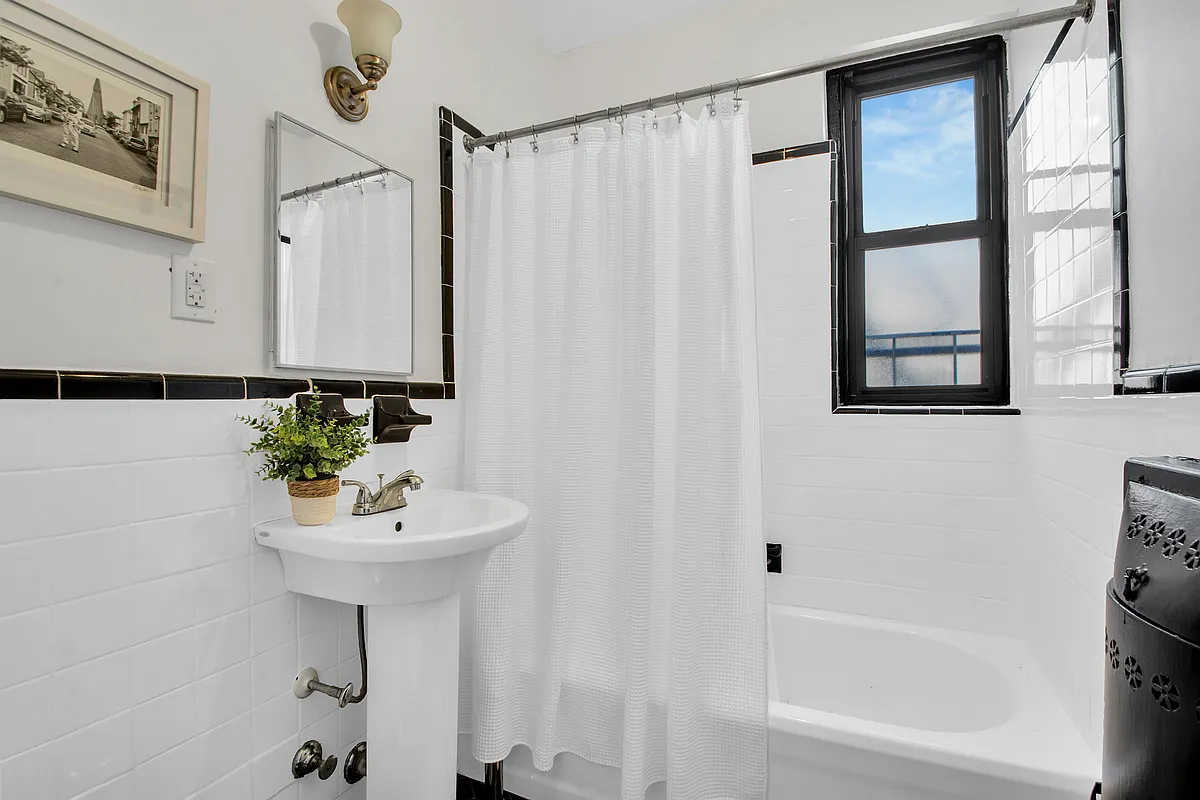 bathroom with black and white tile, white pedestal sink