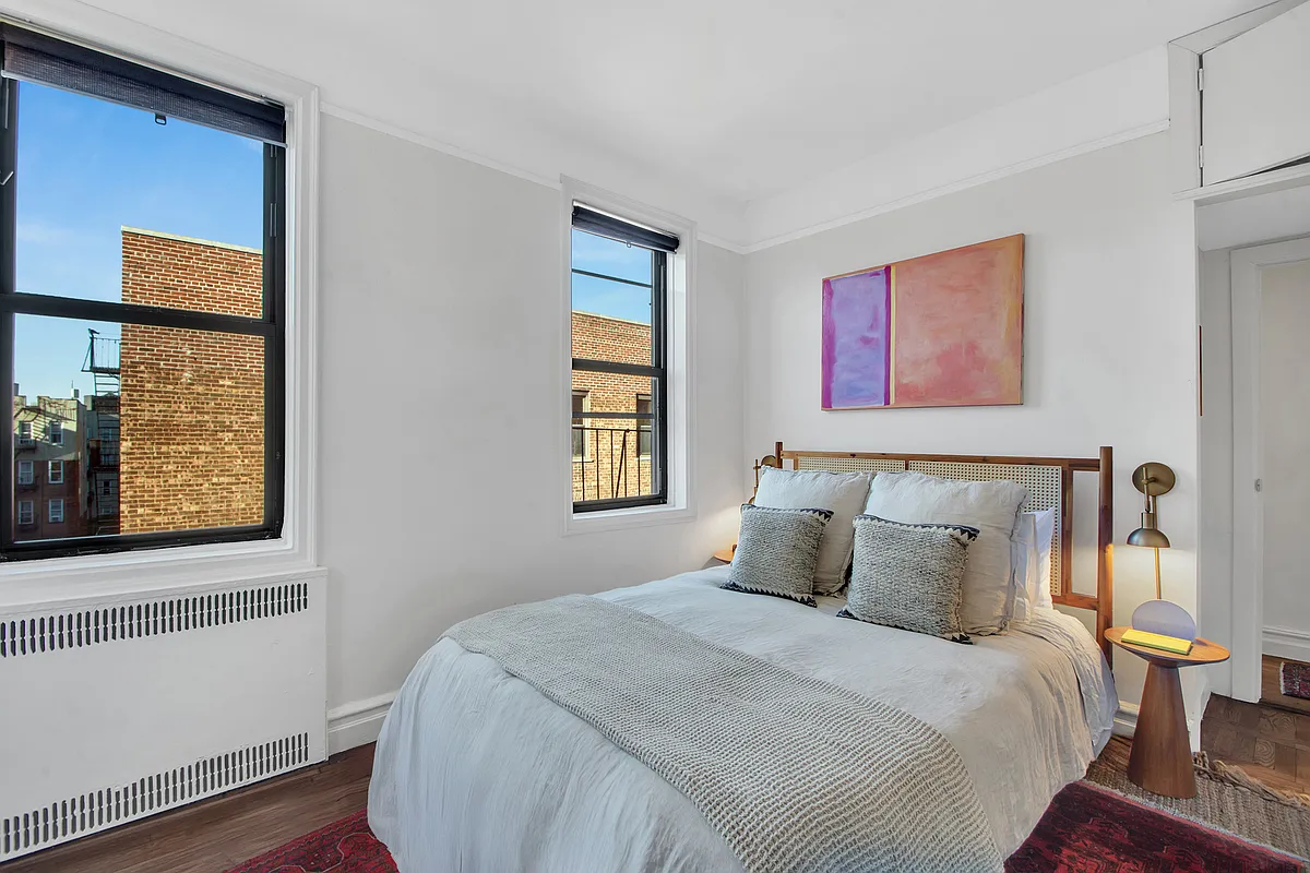 bedroom with two windows, built-in storage above door