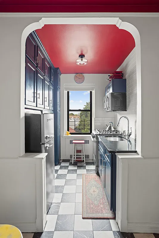 kitchen with blue cabinets, red ceiling and white subway tile