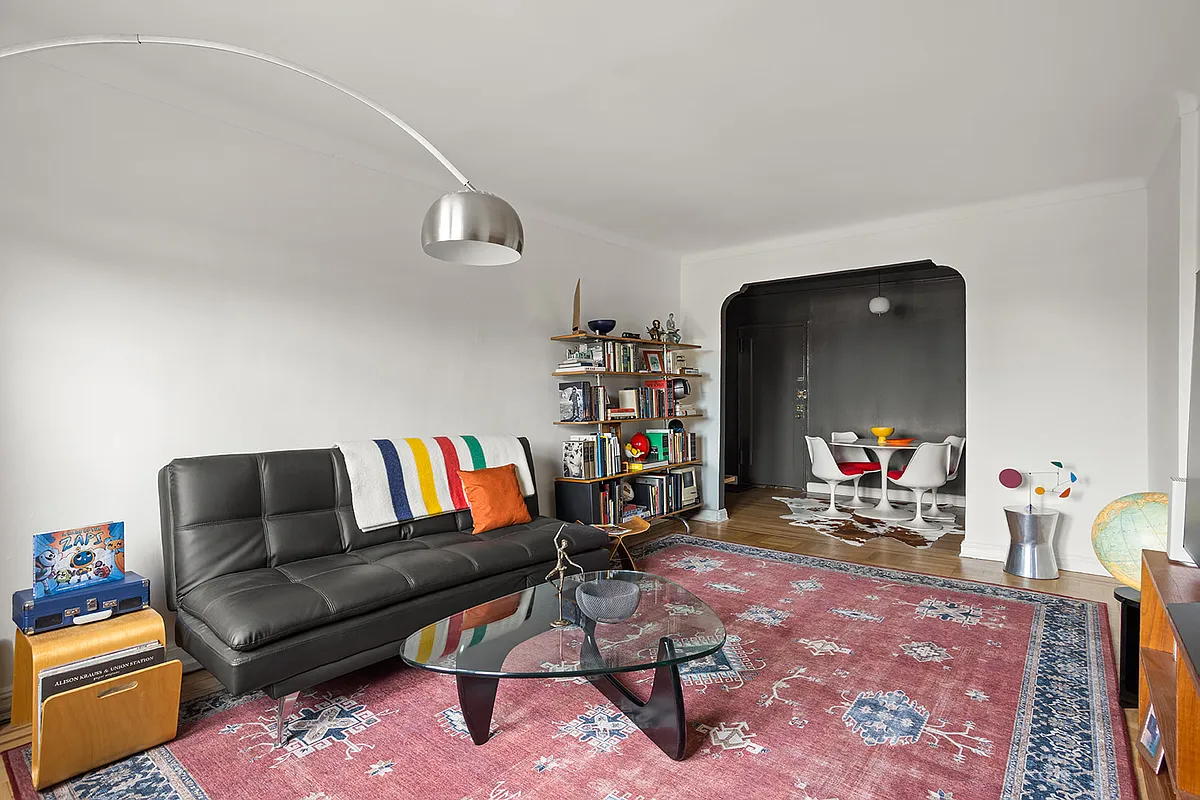 living room with white walls and arched doorway into the foyer