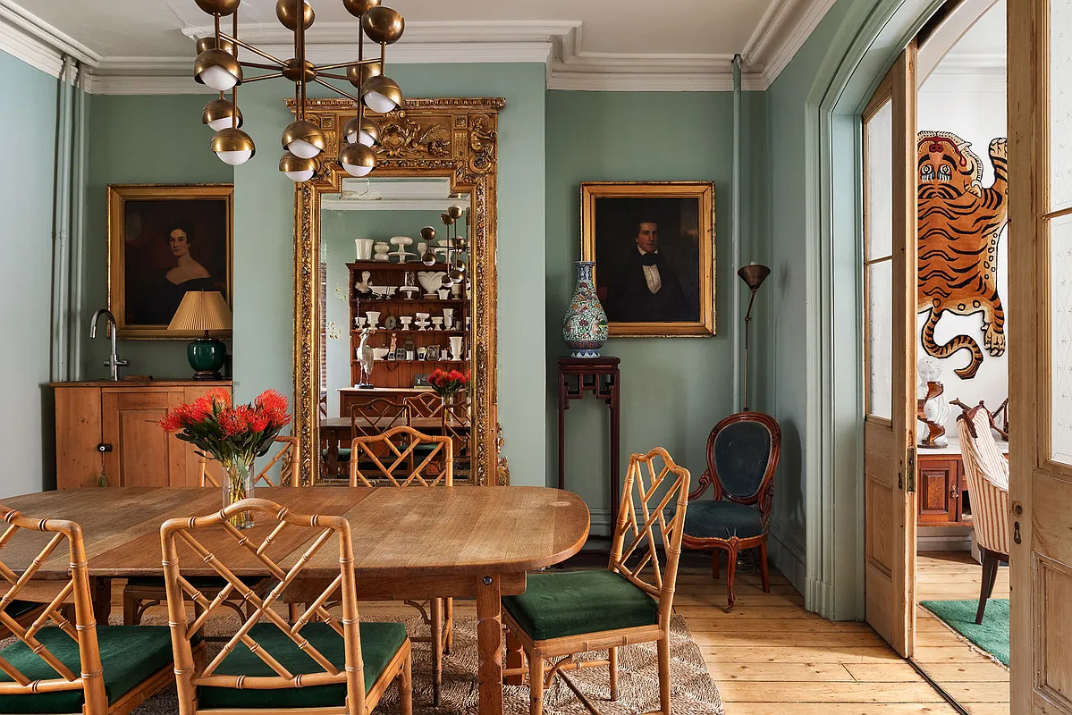 dining room with green walls, wood floor, pocket doors to front parlor