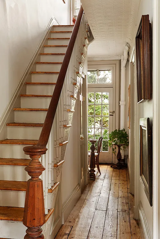 entry hall with wide planked floorboards, original stair with newel post