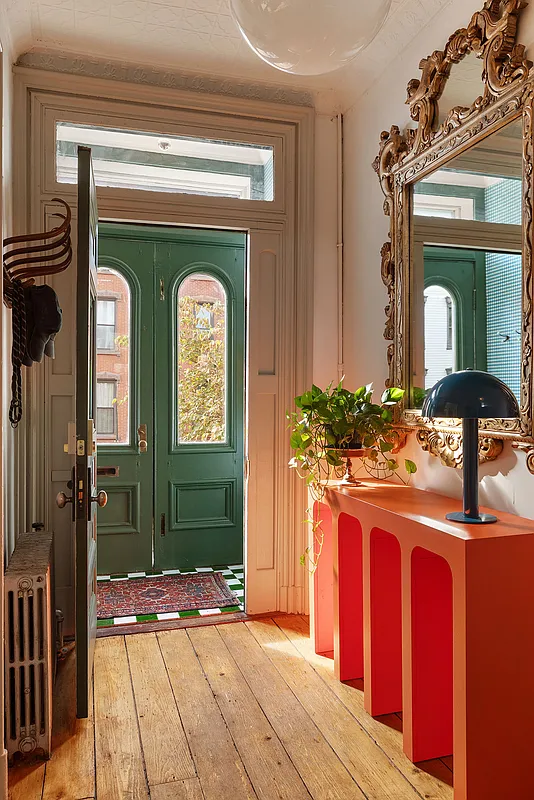 entry hall with wide planked floorboards view to green entry doors