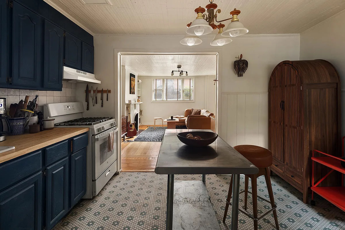 garden level kitchen with blue cabinets and white and blue hex tile floor