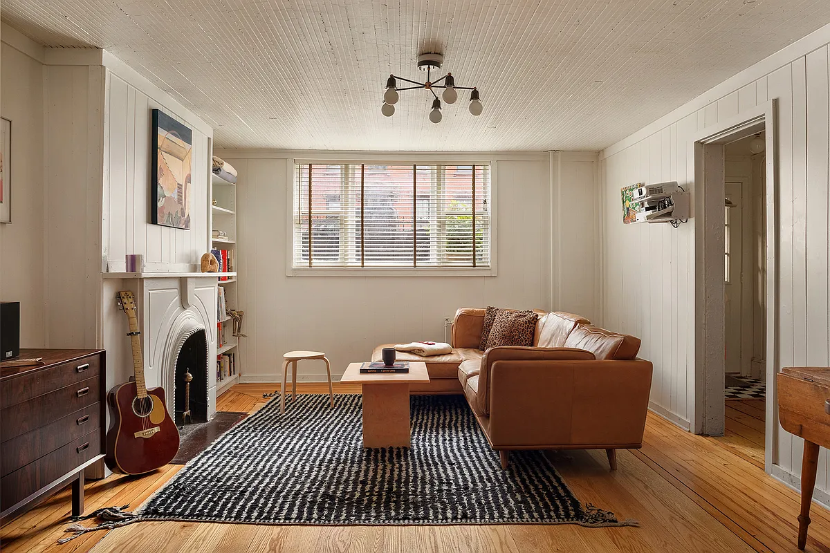 garden level living room with wood slat ceiling, marble mantel