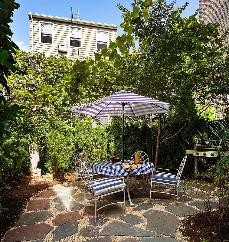 rear yard with paved patio surrounded by shrubbery