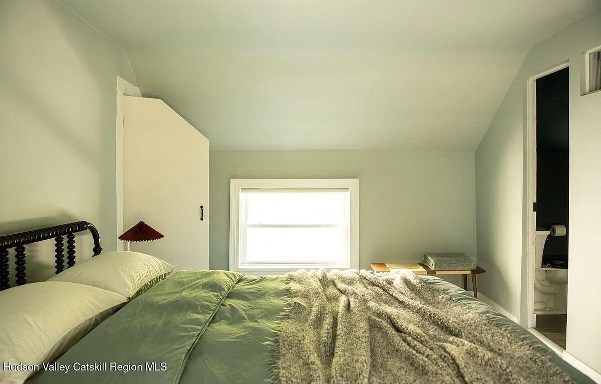 bedroom with low window and door to an en suite bath
