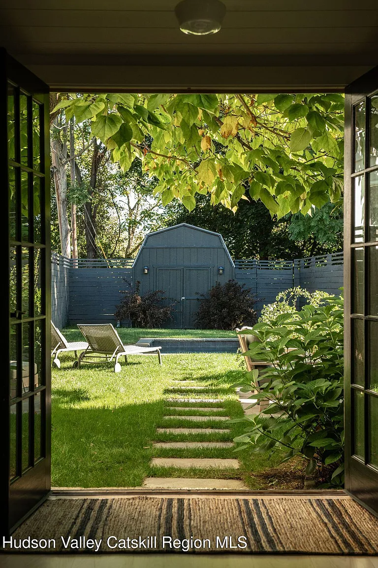 view from french doors to rear yard pool and shed