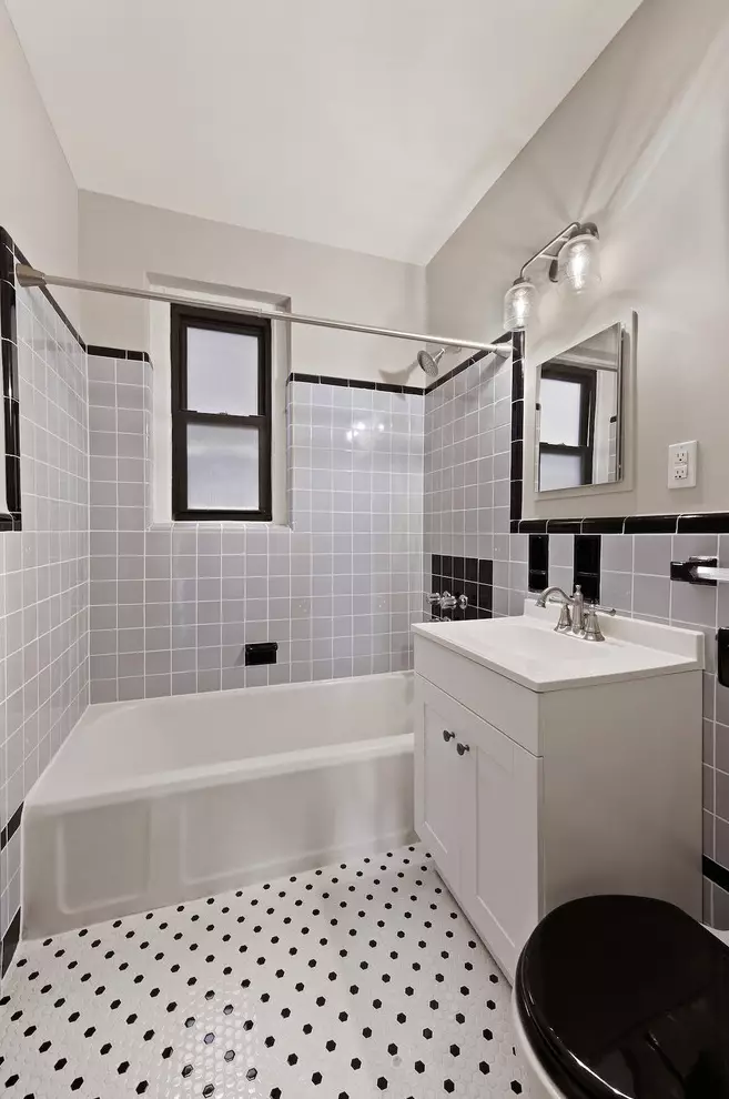 bathroom with white fixtures, gray wall tile