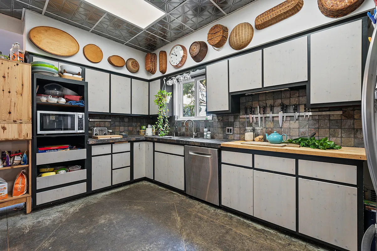 kitchen with concrete floor, white cabinets