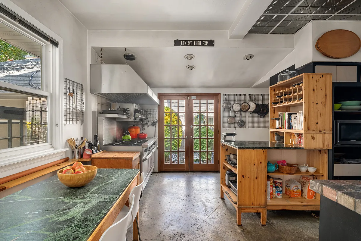 kitchen with concrete floor, industrial hood over stove