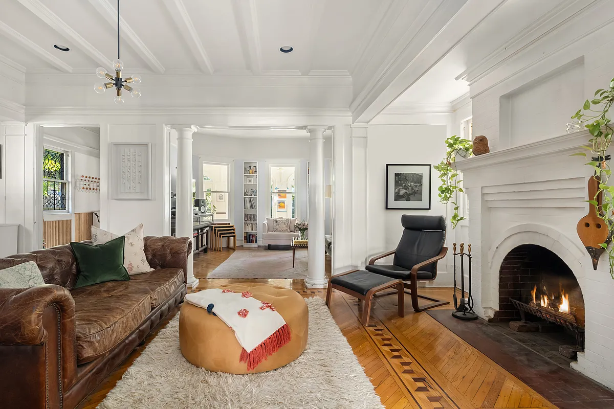 front parlor with arched brick mantel, wood floor