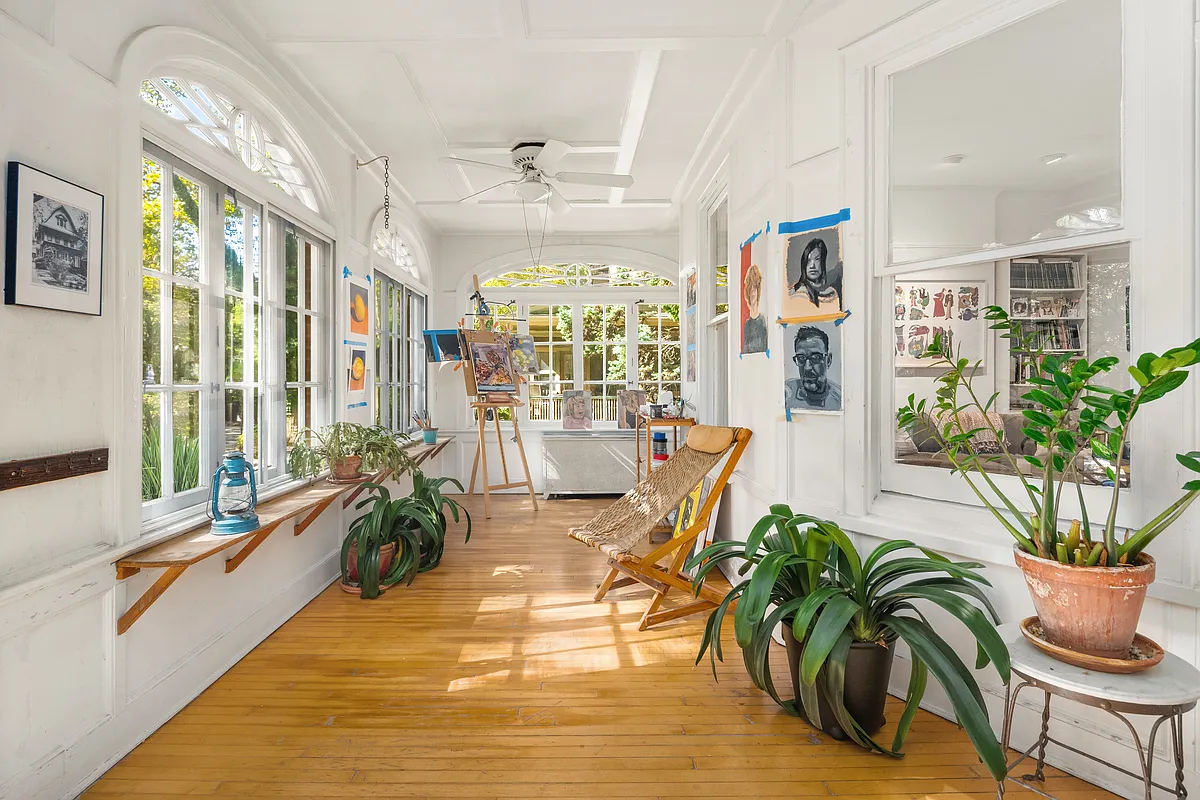 enlcosed porch with white walls set up as a studio space