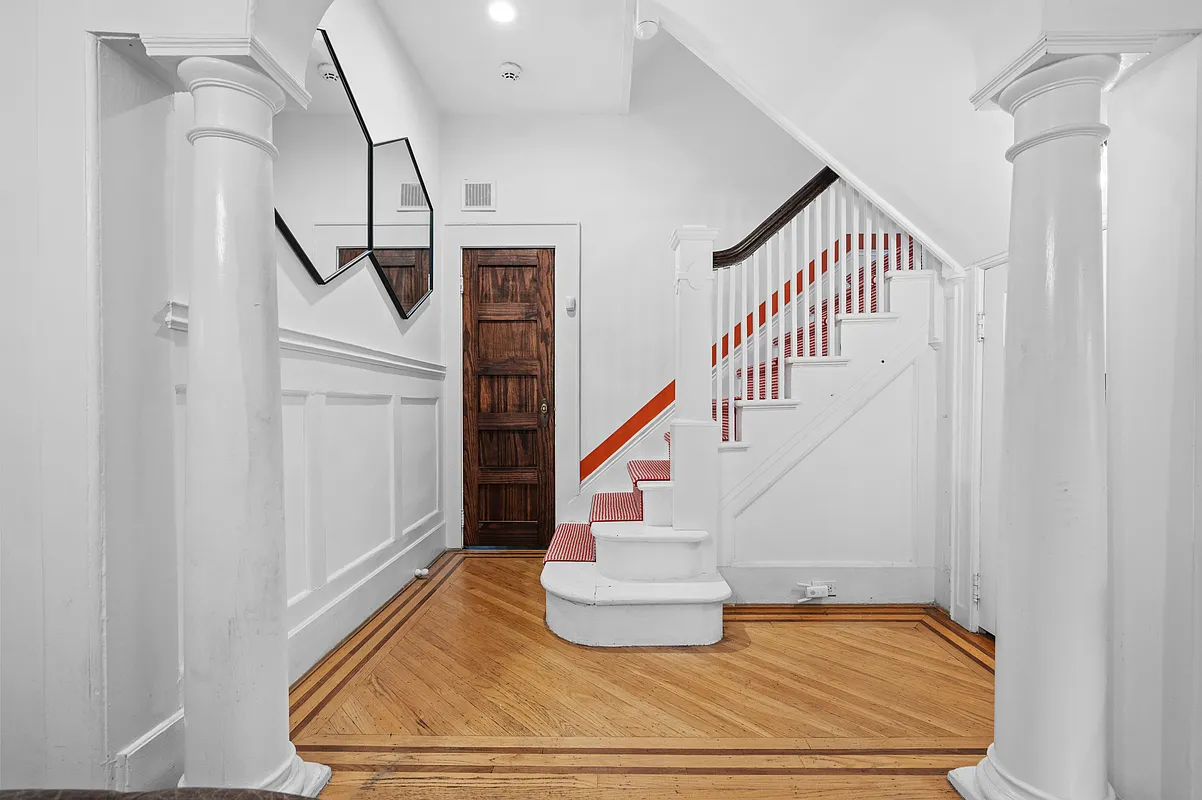 foyer with stair with red and white striped runner